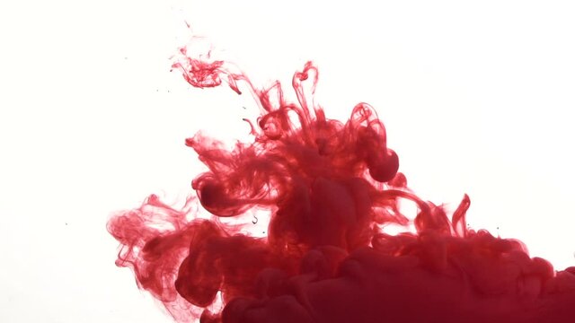 Real shot color paint drops in water in slow motion. Ink swirling underwater. Red paint. Close up view