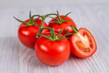 Raw and fresh-cut tomatoes on a white wooden table. Luminous background.