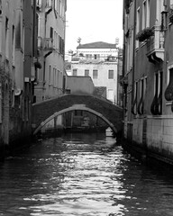 Venice, Italy, December 28, 2018 evocative black and white image of a typical Venice canal with connecting bridge
