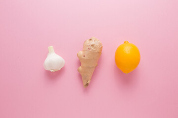 Lemon garlic ginger on a pink background. The body's natural defense against disease.