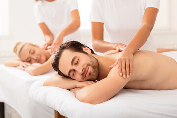 Husband Relaxing During Couples Massage With Wife At Spa Salon
