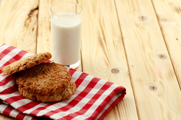 Oat cookies and glass of milk on wooden table
