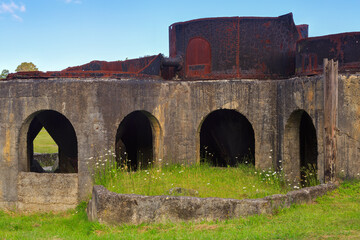Fototapeta na wymiar The remains of the Victoria (mining) battery in the Karangahake Gorge, New Zealand. These cyanide tank stands, built in 1897, were used to extract gold from ore