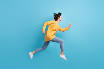 Fototapeta na wymiar Full length body side profile photo of happy girl running fast jumping high isolated on bright blue color background