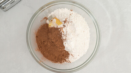 Chocolate buttercream icing preparation process. Mixing ingredients together in a glass bowl