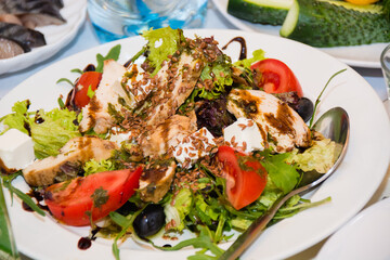 Festive Christmas meal, a salad of chicken with tomatoes, flax seeds, cheese and green vegetables.