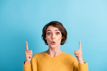 Photo portrait of surprised girl with bob hairstyle pointing up at copyspace with fingers staring...