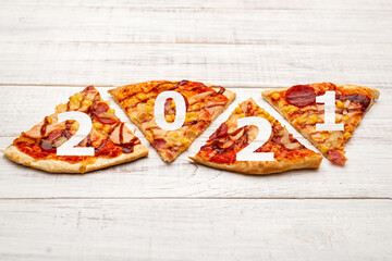 2021 and pizza. Christmas theme made from slices of pizza.