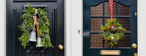 Set of Christmas wreath on entrance vintage doors outdoor. Two vintage front doors decorated by christmas festive wreath decor with bells and ribbons. Traditional Christmas exterior in Netherlands © Beton Studio