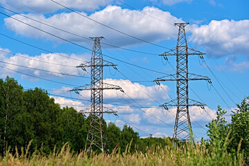 Obraz premium A long line of electrical transmission towers carrying high voltage lines.