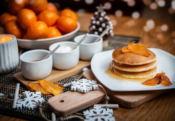 Festive table setting with vegane pancakes and tangerines