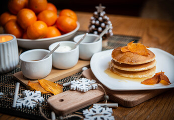 Festive table setting with vegane pancakes and tangerines
