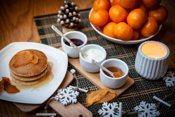 Festive table setting with vegane pancakes and tangerines