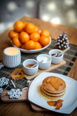 Festive table setting with vegane pancakes and tangerines