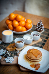 Festive table setting with vegane pancakes and tangerines