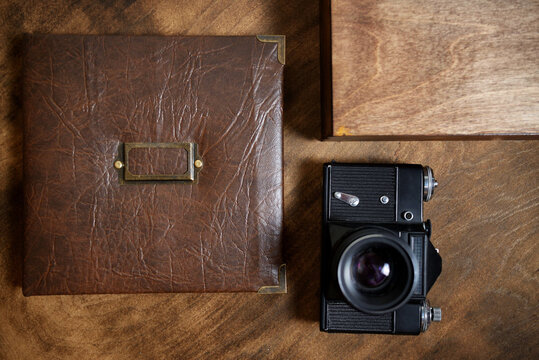 gift photo book in a leather cover in a wooden box on a wooded background. Vintage photo album.