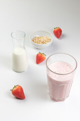  strawberry cereal cocktail for breakfast in a glass cup on a white plate with ingredients. shooting from top to bottom. flat composition. with free space for text, labels and logos