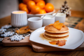 Festive table setting with vegane pancakes and tangerines