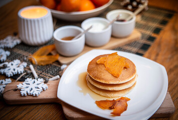 Festive table setting with vegane pancakes and tangerines