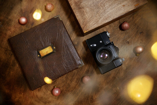 gift photo book in a leather cover in a wooden box on a wooded background. Vintage photo album.