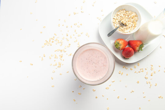  strawberry cereal cocktail for breakfast in a glass cup on a white plate with ingredients. shooting from top to bottom. flat composition. with free space for text, labels and logos