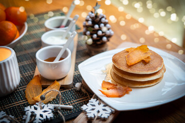 Festive table setting with vegane pancakes and tangerines