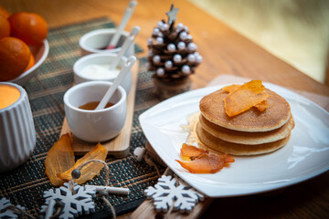 Festive table setting with vegane pancakes and tangerines