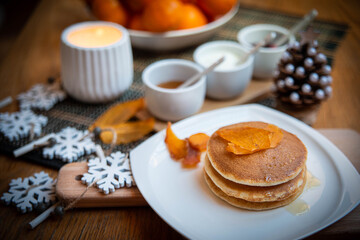 Festive table setting with vegane pancakes and tangerines