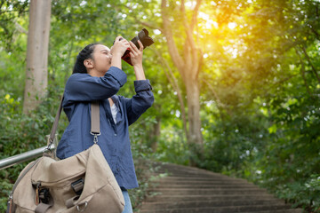 Traveler with a photo camera in hand outdoor in the forest