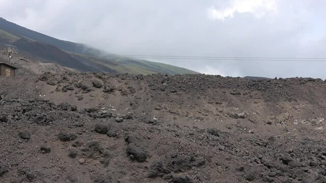 Picturesque volcanic landscape of Mount Etna view from cableway, Etna national park, Sicily, Italy. Smoke and clouds, footage in 4k
