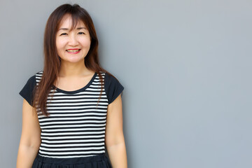 Obraz premium Portrait healthy asian woman with gray wall background copy space. Happy customer woman get enjoying life with smile face. She get satisfied something. Health care and insurance concept