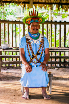 Ecuador. A Shaman from the Siona Community in his traditional costume stands model for a photo. Taken in the Amazonian territory near Puerto Bolivia on the Cuyabeno river