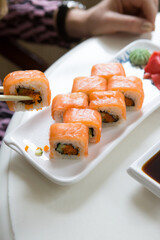 Woman eating japanese sushi rolls