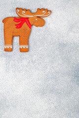 Christmas homemade gingerbread cookies, winter holiday treat in the shape of a elk (moose, deer) on a grey concrete background. Selective focus, copy space