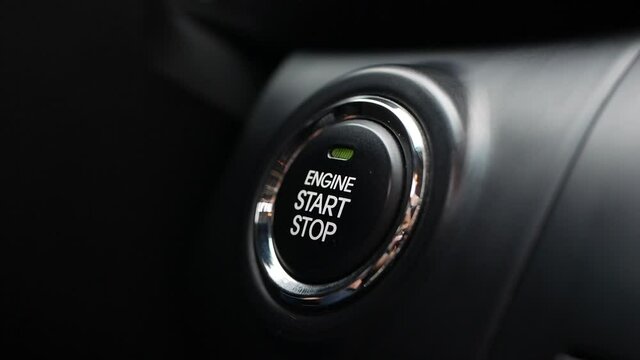 Man is pressing the button engine start in car. Start car engine by pushing a button. Close-up.