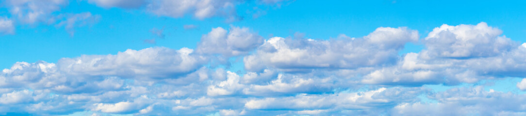 Panorama of blue sky with white volumetric clouds