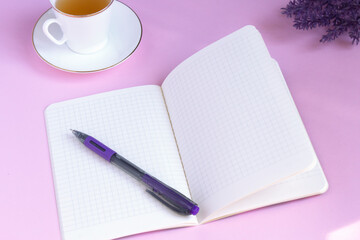 Open blank Notepad with a pen on a pink background with a white Cup of tea. Template, layout for posters, social networks, stories. Top view. Copy space.