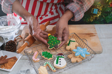 Hands of the chef present Christmas tree cookies and a variety of cookies on the back tray, top view, Christmas time