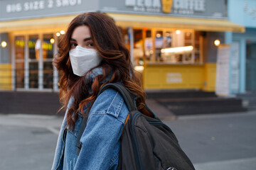 Obraz premium A woman standing in front of a building wearing a mask