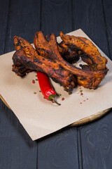 Fried ribs with pepper a on black wooden background