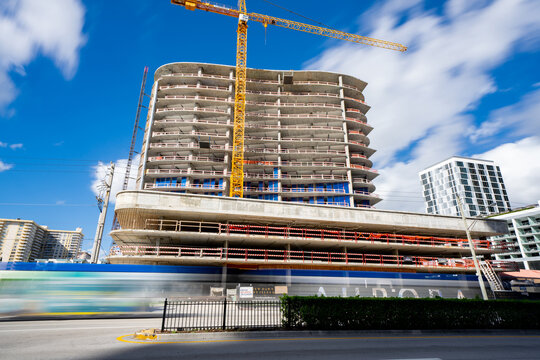Sunny Isles Beach, FL, USA - November 24, 2020: Long exposure construction site crane with traffic blurred on road