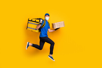 Full body profile photo of guy wear cup bag running hold pos wear face mask isolated on yellow color background