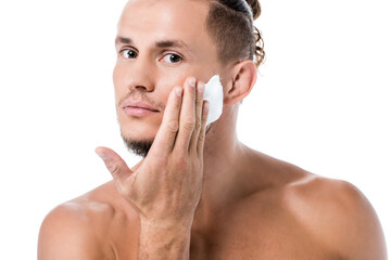  shirtless man applying foam on face isolated on white