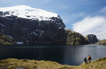 Fototapeta na wymiar Two Hikers Looking At Mountain Lake