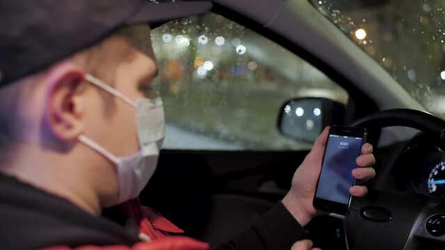 Tired man in medical protection mask declines boss call late night afterwork due to remote work. A cellphone rings with a phone call from boss. The call is ignored by exhausted courier during second