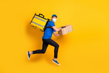 Full size profile portrait of guy jump run wear blue medical face cold safe mask isolated on yellow color background