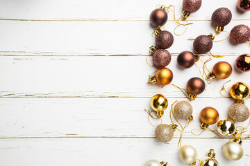 Naklejka na ściany i meble Christmas gold and brown decorations on white wooden background, top view. Winter Decoration Background