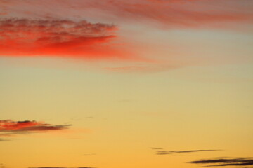 Sun below the horizon and clouds in the fiery dramatic orange sky at sunset or dawn backlit by the sun. Place for text and design