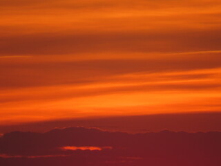 yellow-orange sky after sunset with purple clouds