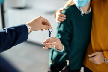 Close-up of a couple receiving key of their new real estate.
